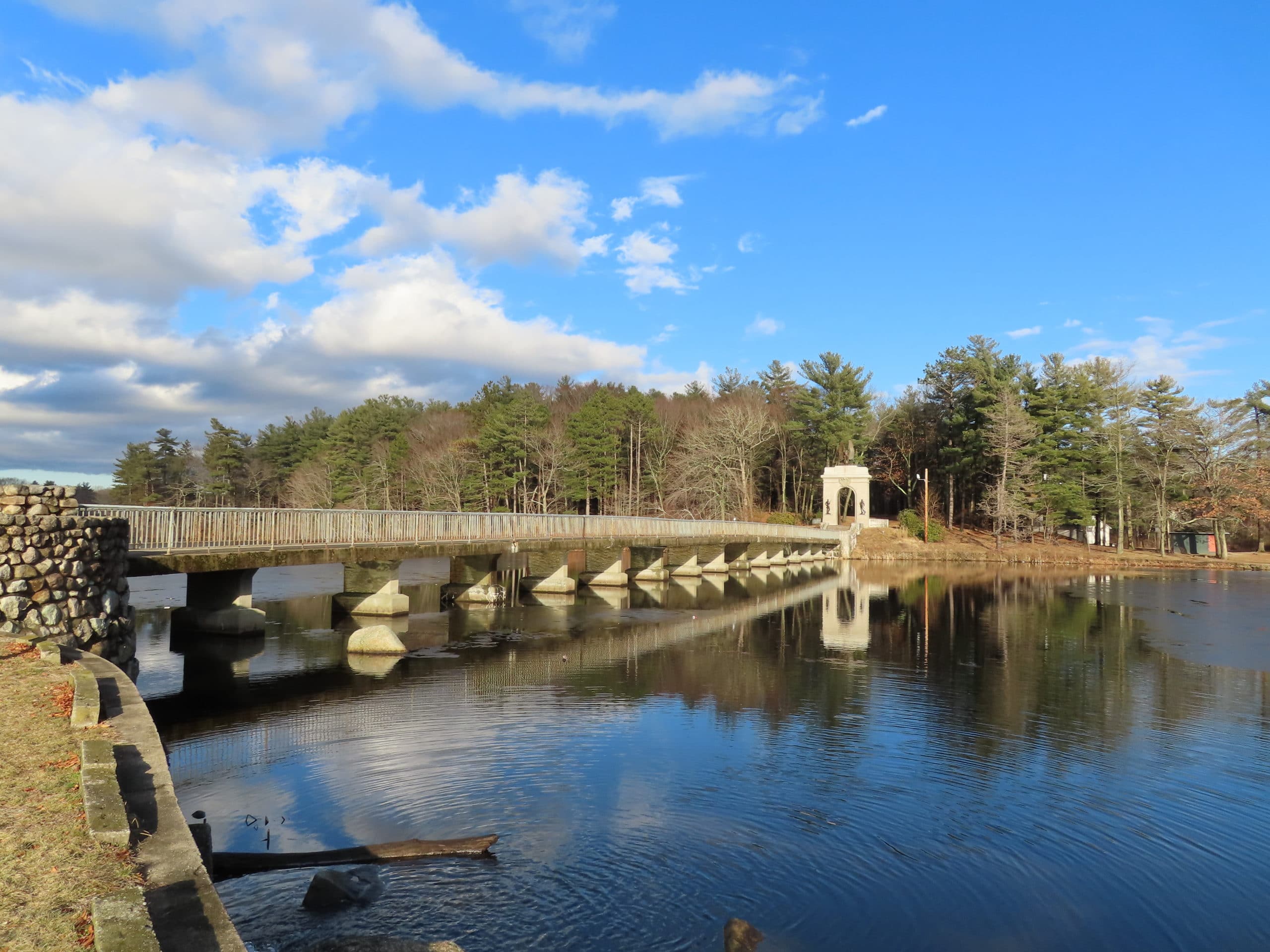 Island Grove Pond, the walking bridge, and the memorial arch reflected in the water